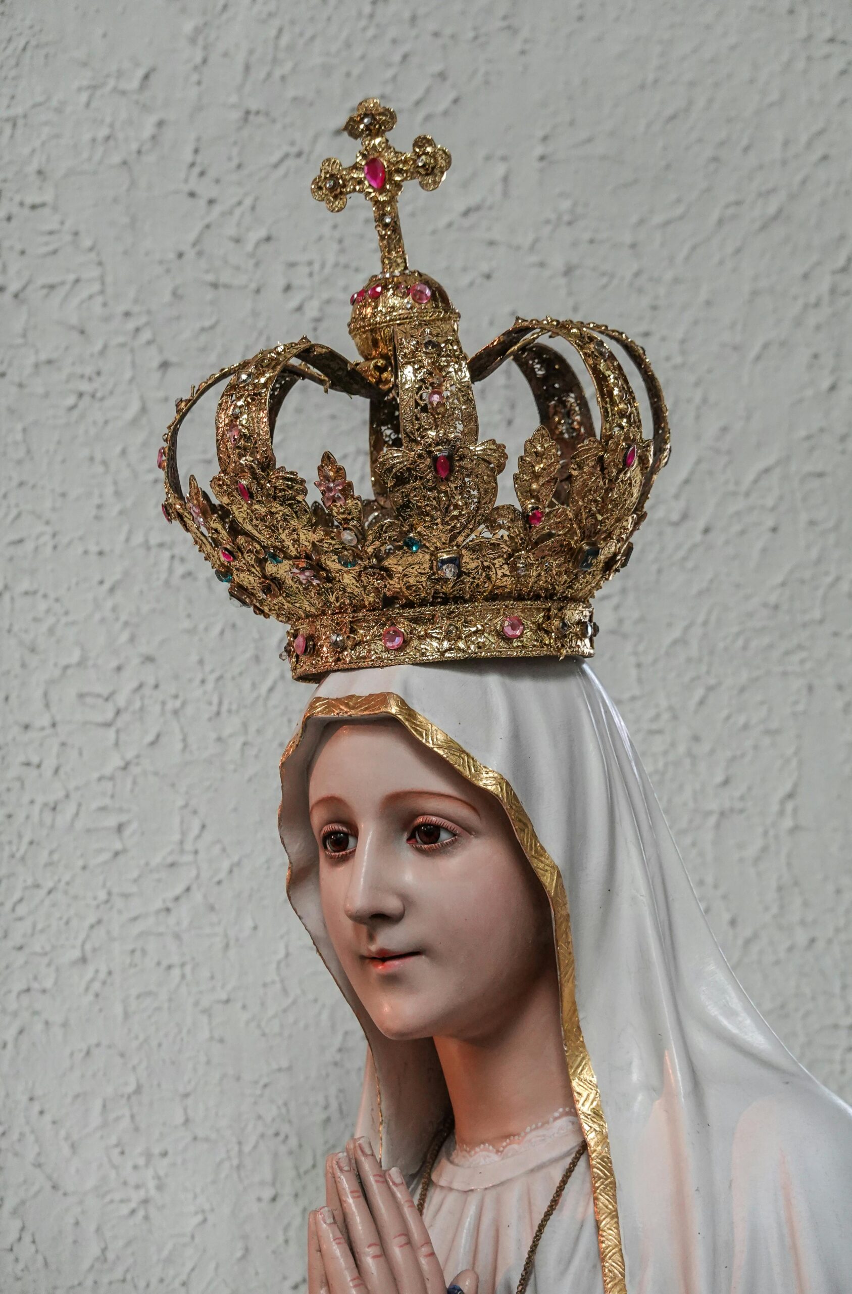 Close-up of a Virgin Mary statue with an ornate golden crown, symbolizing religious devotion.