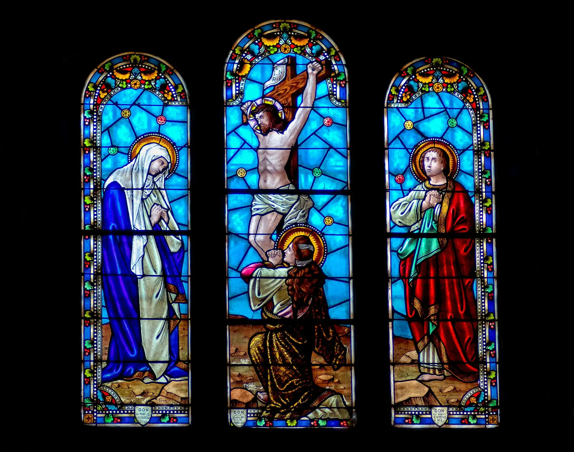 Colorful stained glass window illustrating the crucifixion of Jesus Christ inside a church.